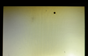 LCD display exposed to intense sunlight with visible black spots, yellowing, and faded colors